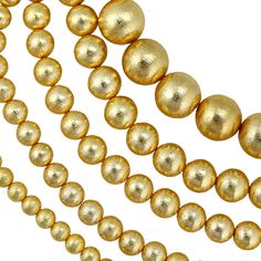 three strands of gold colored beads on a white background