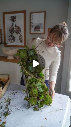 a woman is cutting up some plants on a table