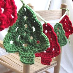 crocheted christmas tree decorations hanging from a wooden chair