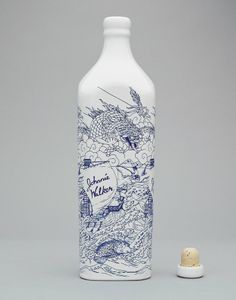 a white bottle with blue designs on it next to a corkscrew wine stopper