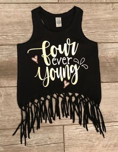 a black crop top with gold lettering and fringes