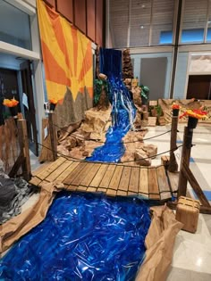 a wooden bridge over a blue river in an office building