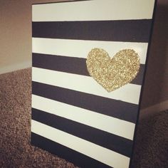 a black and white striped canvas with a gold glitter heart on the side, sitting on carpet