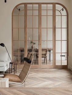 a living room filled with furniture next to a white couch and wooden floored walls