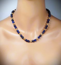 The necklace is made of 8mm blue lapis lazuli and 6mm gold lava beads.  A length is 17.25'' - 20.25'' (43cm - 50cm).  Your necklace is ready to ship. Thank you for visiting my shop. Gold Lapis Lazuli Spiritual Necklace, Gold Lapis Lazuli Necklace With Gemstone Beads, Gold Necklaces With Lapis Lazuli Gemstone Beads, Gold Necklace With Lapis Lazuli Gemstone Beads, Gold Single Strand Lapis Lazuli Beaded Necklace, Blue Lapis Lazuli Necklace With Spacer Beads, Gemstone Choker, Lapis Lazuli Gemstone, Lava Beads