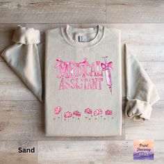 🎀 Show your support for medical assistants with this adorable pink tee or sweatshirt! Perfect for everyday comfort, this girly, coquette-style top features a cute design that healthcare workers will love. A great nursing gift or a sweet addition to your casual wardrobe. 🌸🩺  Comfort Colors 1717 is a fully customizable tee made 100% with ring-spun cotton. The soft-washed, garment-dyed fabric brings extra coziness to your wardrobe while the relaxed fit makes it an excellent daily choice. The dou Pink Pre-shrunk Cotton Sweatshirt, Casual Pink Nursing Tops, Girly Coquette, Coquette Style, Healthcare Workers, Gift For Nurse, Medical Assistant, Pink Tee, Comfort Colors Tee