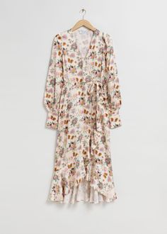 a floral print dress with ruffled hems and long sleeves, hanging on a hanger