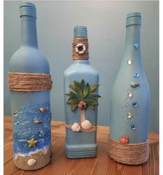 three blue bottles with palm trees and seashells on them