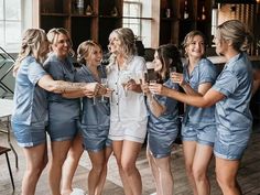 a group of women standing next to each other holding wine glasses