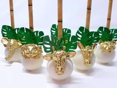 four vases with fake plants in them on a white tableclothed background and bamboo sticks sticking out of the top