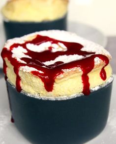 a close up of a cake on a plate with red sauce drizzled over it