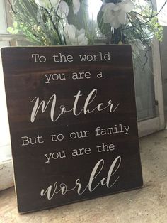 a wooden sign that says to the world you are a mother but to our family you are the world