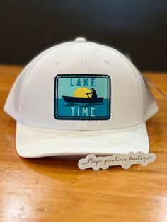 Where are all our lake goings? We have the hat for you! This super cute embroidered "patch" baseball cap is adjustable and unisex. Available in white and navy. White Cotton Trucker Hat For Outdoor, White Hat With Curved Bill And Letter Patch, White Cotton Trucker Hat With Logo Patch, White Snapback Hat For Outdoor Activities, White Trucker Hat With Logo Patch For Baseball Season, White Trucker Hat With Logo Patch And Curved Brim, White Hat With Logo Patch And Curved Brim, White Baseball Hat With Embroidered Logo, White Outdoor Hat With Embroidered Logo