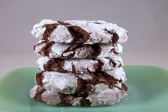 a stack of chocolate crinkle cookies sitting on top of a green platter