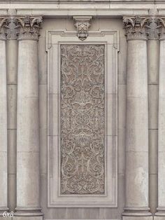 an old building with columns and a decorative panel on the front wall that looks like it has been carved from stone