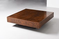 a square wooden table sitting on top of a white floor