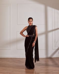 Black halter blouse with pre draped saree having hand embroidered border and detatchable belt.Black predraped saree set with belt No. of pieces in a set: 3 Color: Black Fabric Composition: Opada silk, georgette, organza Lining Material: Shantoon Closure used: Back hook in blouse and side zip in saree. Dress Length : Full Silhouette: Saree Neck type : Halter neck Sleeve Length: Sleeveless Waistline: High waist Prints/ Pattterns : Plain Delivery Time: 20-25 days Halter Blouse Saree, Halter Neck Saree, Pre Draped Saree, Pleated Saree, Saree With Belt, Draped Saree, Halter Blouse, Drape Saree, Embroidered Border