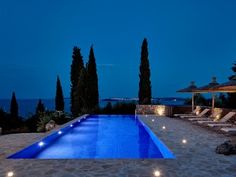 an empty swimming pool surrounded by trees at night