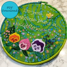 a close up of a circular object on a table with flowers and words written in cursive writing