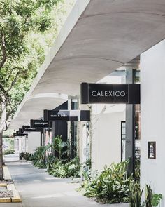 the sidewalk is lined with planters and signs that read calexico on them