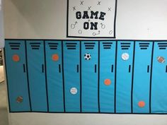 a room with blue lockers and orange balls on the doors that say game on