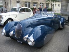 an antique car is parked on the street