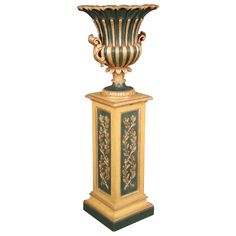 an ornately decorated vase on top of a marble pedestal with gold and green accents