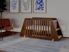 a baby's crib in the corner of a room with three paintings on the wall