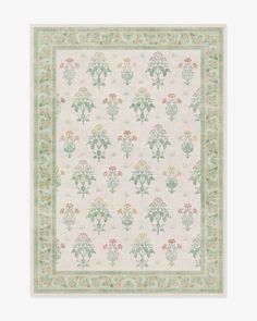 a white rug with green and yellow flowers on the bottom, in front of a beige background