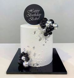 a white cake with black and silver decorations