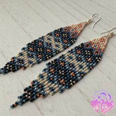 two pairs of beaded earrings on top of a wooden table