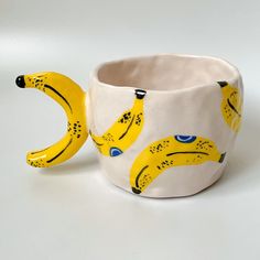 two bananas are painted on the inside of a cup that is shaped like a banana