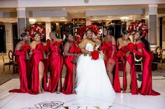 a group of women standing next to each other in red dresses