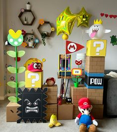 nintendo themed birthday party with balloons, decorations and mario papercrafts on cardboard boxes