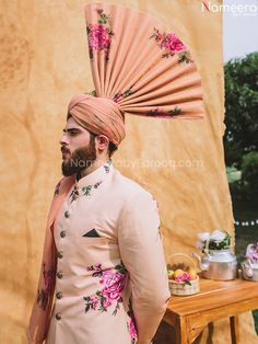 Designer Mens Sherwani in Peach Sherwani Style is all set to make a lasting impact in its unique style and print on men's sherwani. It will be your wedding outfit for sure if you are looking for an elegant and graceful Peach sherwani. Sherwani: Men Sherwani in Peach color is fully enhanced with floral prints on raw silk jamawar with Golden Engraved buttons. Pink Floral Print organza fabric High Rise turban is paired with floral men's sherwani. Trouser: The classic attire comes in with straight t Peach Sherwani, Men Sherwani, Mens Sherwani, Groom Wear, Pink Floral Print, Organza Fabric, Straight Trousers, Peach Color, Churidar