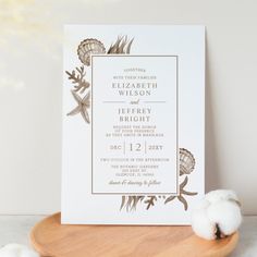 the wedding stationery is displayed on a wooden plate next to cotton balls and cotton swabs