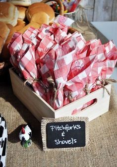 there is a wooden box filled with red and white napkins next to other food items