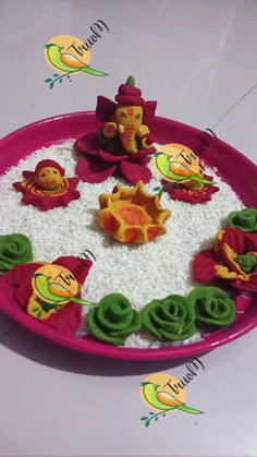 a pink plate topped with lots of different types of decorations on top of white rice