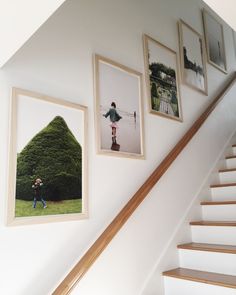 an image of some pictures hanging on the wall next to a stair case in a house