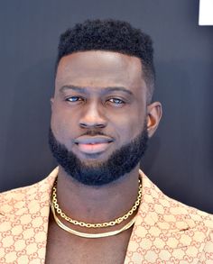 a close up of a person wearing a shirt and a gold chain around his neck