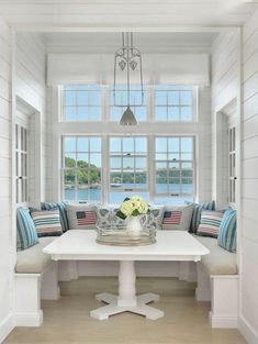 a white table with blue and red pillows on it