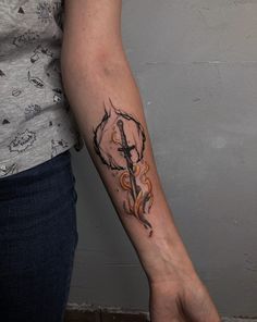 a woman with a tattoo on her arm holding a knife and cross in the middle