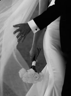 the bride and groom are holding hands with each other as they walk down the aisle