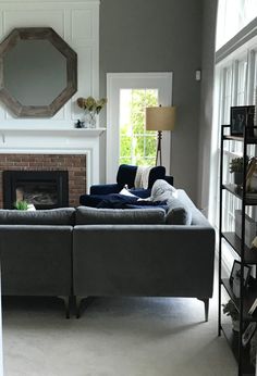 a living room filled with furniture and a fire place under a mirror on the wall