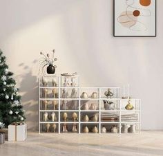 a christmas tree is next to a white shelf with shoes on it and other decorations