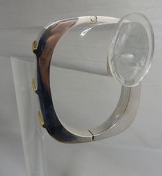 "Here's a stylishly modern hinged bangle bracelet, made in sterling silver and signed with Juan Sandoval Vazquez's Two Trees logo. It has gold vermeil accents on the front in a diagonal pattern, Interior circumference is 6.3/4\" and it is 3/8\" wide. It weighs 42 grams and is fully hallmarked. It is in exceptional pre-owned condition with no scratches or damage. Thanks for looking." Formal Modern Sterling Silver Bracelet, Modern Polished Sterling Silver Bracelet, Modern Metal Bangle With Polished Finish, Modern Sterling Silver Bracelet For Formal Occasions, Modern Adjustable Bangle With Polished Finish, Modern Sterling Silver Bangle Bracelet, Modern Adjustable Sterling Silver Bracelet, Adjustable Modern Sterling Silver Bracelet, Modern Adjustable Hinged Bracelets