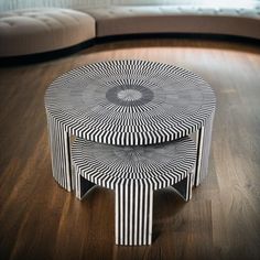 two black and white tables sitting on top of a hard wood floor next to a couch