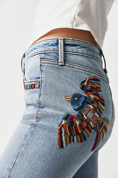 a woman's jeans with an embroidered bird on it