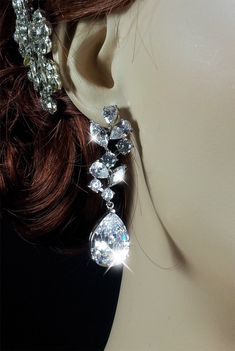 a woman's head wearing a pair of earrings with crystal stones on the side