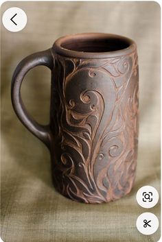 a brown mug with intricate designs on it